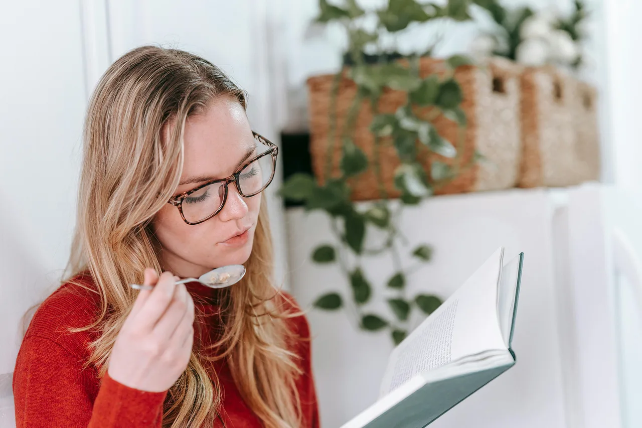 thực phẩm bảo vệ răng miệng Cô gái đang ngồi đọc sách và ăn thực phẩm