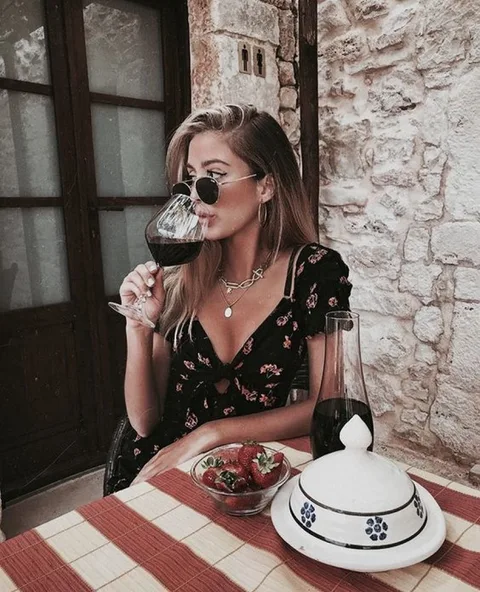 Người phụ nữ thưởng thức ly rượu vang đỏ một cách thư thái